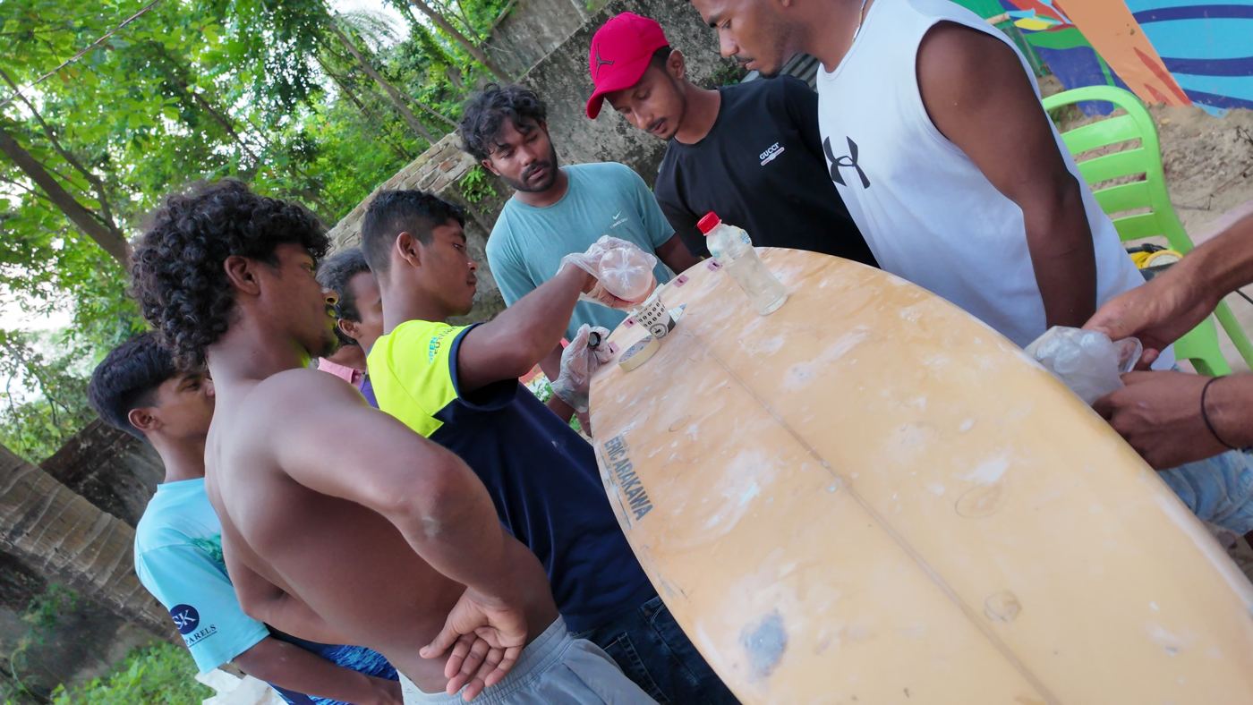 Local surfers repairing boards together at Kolatoli, Cox's Bazar