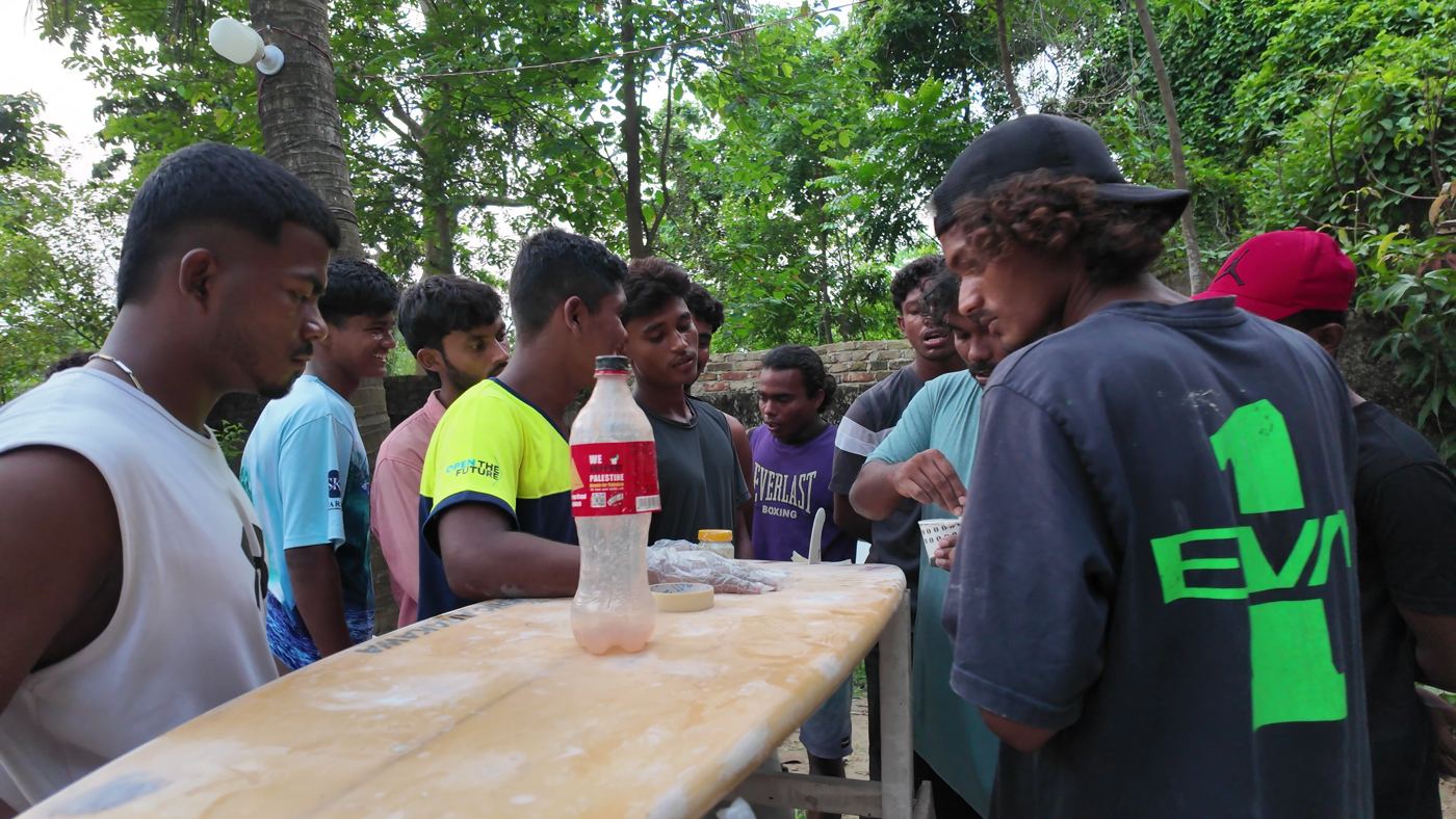 Local surfers repairing boards together at a community day