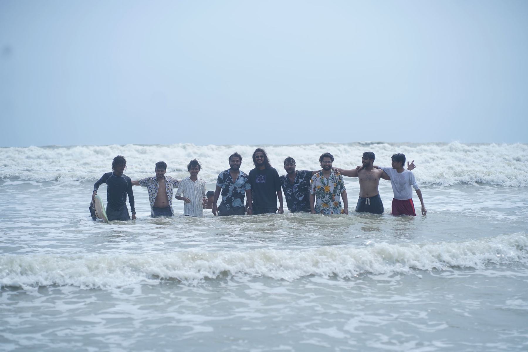 The Surf Hub crew standing together in the waves at Kolatoli, Cox's Bazar