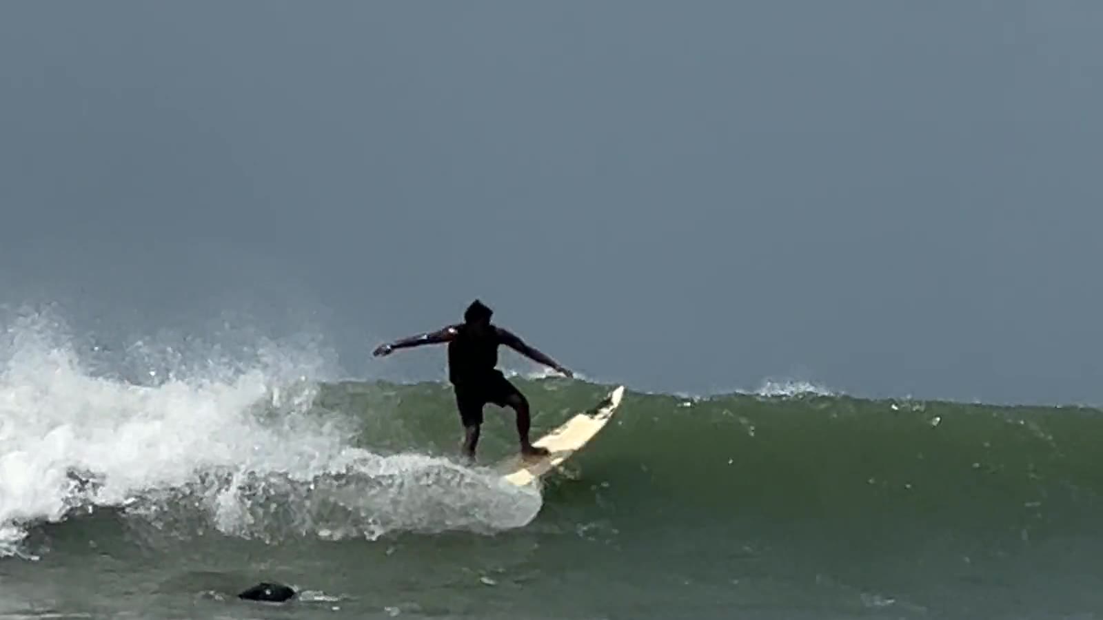 A local surfer carving a wave at Cox's Bazar