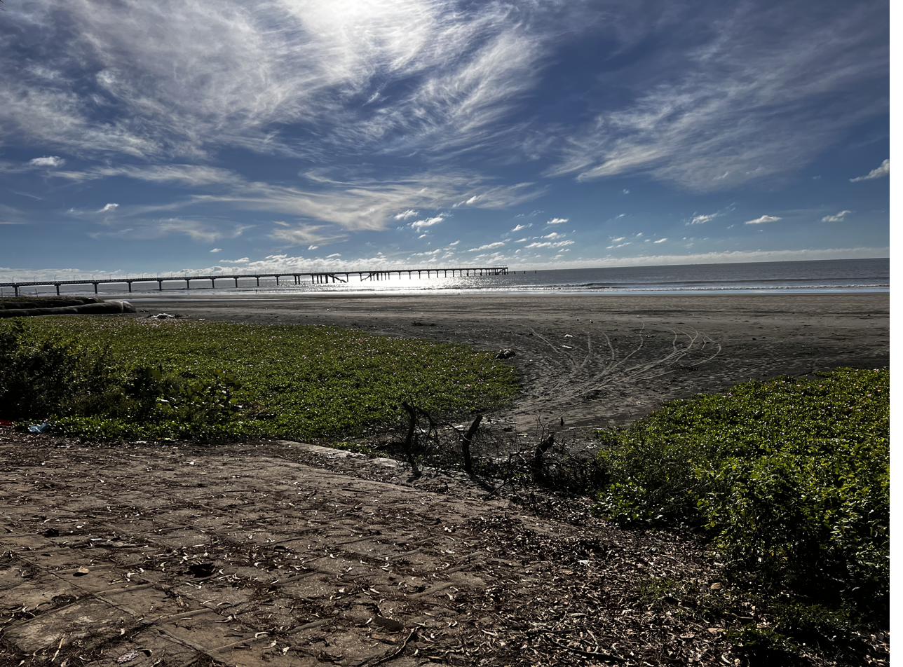 Cox's Bazar coastline — pier and Bay of Bengal at low tide