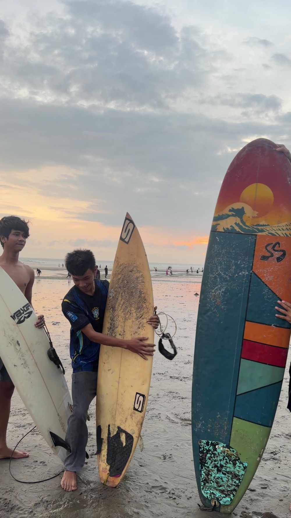 Local surfers with their boards at sunset on Cox's Bazar beach